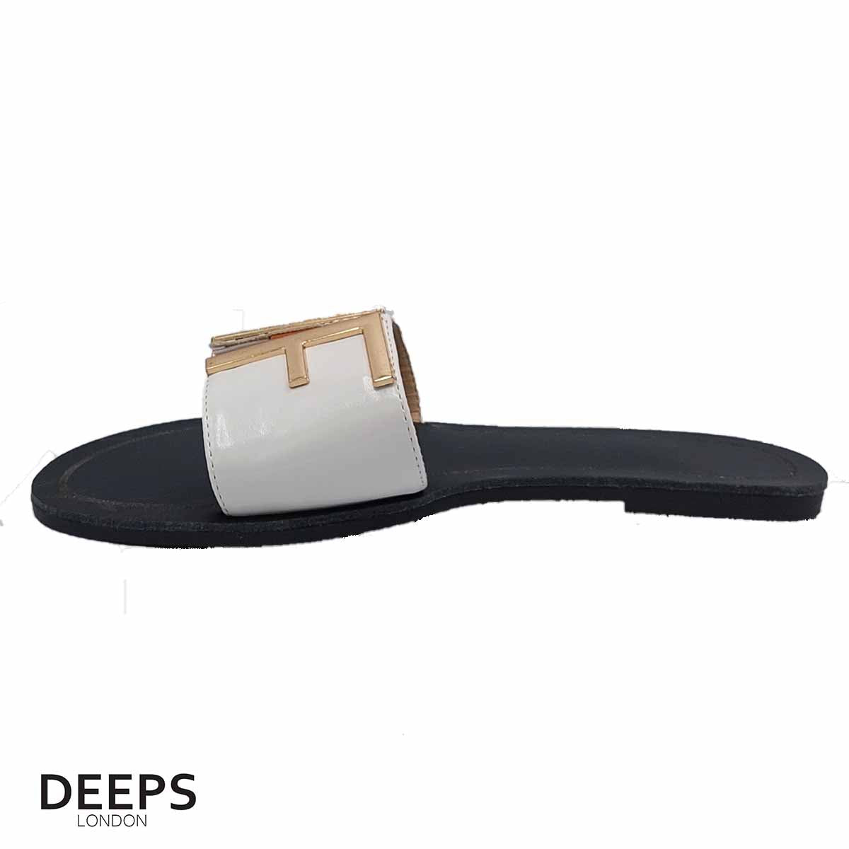 side profile of the gold bar detail on women's white open toe flat slider sandals, highlighting their subtle elegance for London style.
