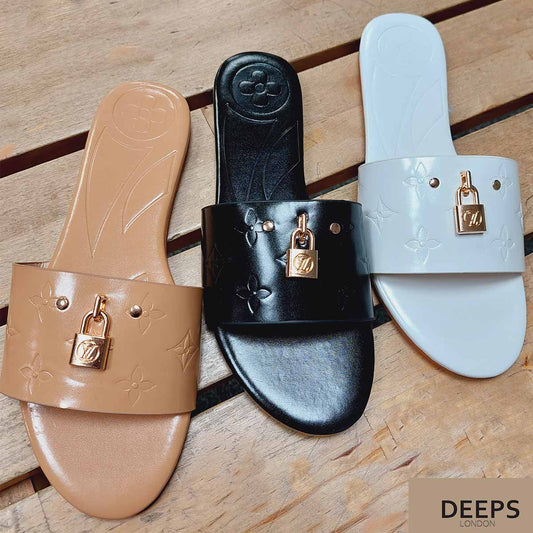 Front view of women's open toe flat slider sandals in beige , black and white with a gold lock detail, a chic and versatile option for London.