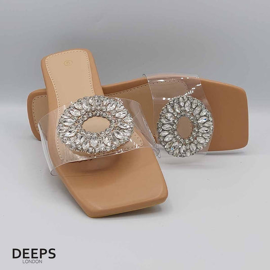 Front view of women's beige perspex flat slider sandals with sparkling diamante embellishments, a glamorous choice for London.