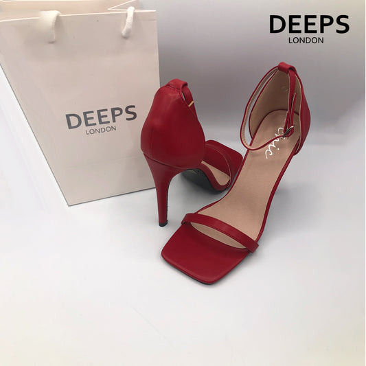 Side profile of women's Radius square toe high heels with buckle ankle strap in red, showcasing the heel and strap detailing for London fashion.