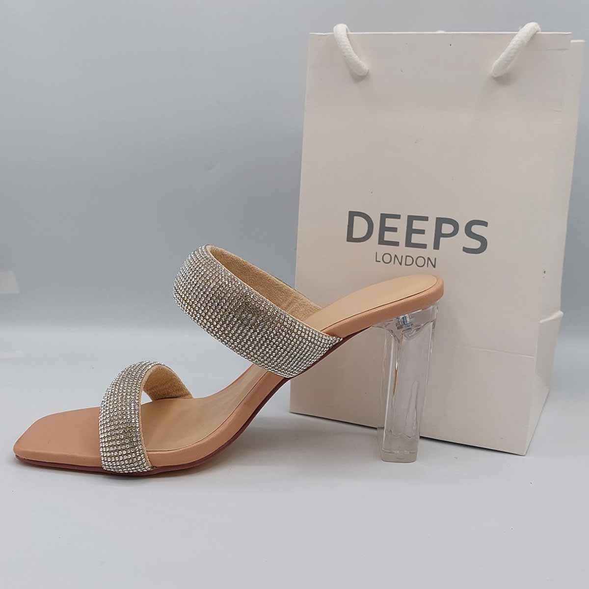 Close-up of the diamante embellishments on the two straps and the clear perspex block heel of women's mules in beige, highlighting their elegant and modern features for London events.