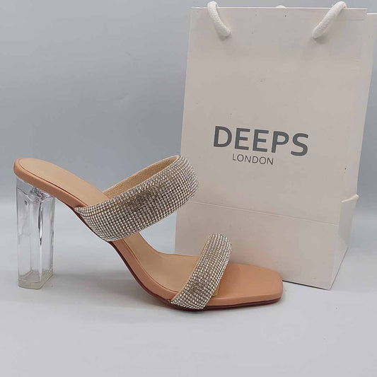 Side profile of women's two-strap diamante clear perspex block heel mules in beige, showcasing the clear block heel and diamante strap detailing for London fashion.