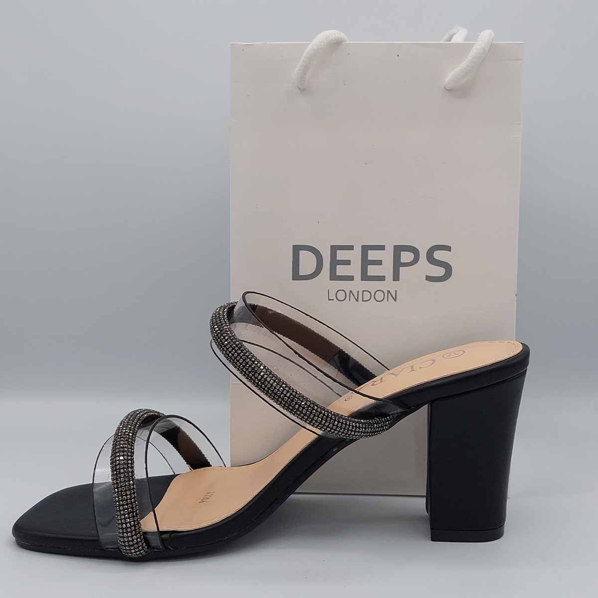 Woman's foot wearing stylish Yuna clear diamante chunky heel mules in black, a fashionable and glamorous choice for London events from DeepsLondon.